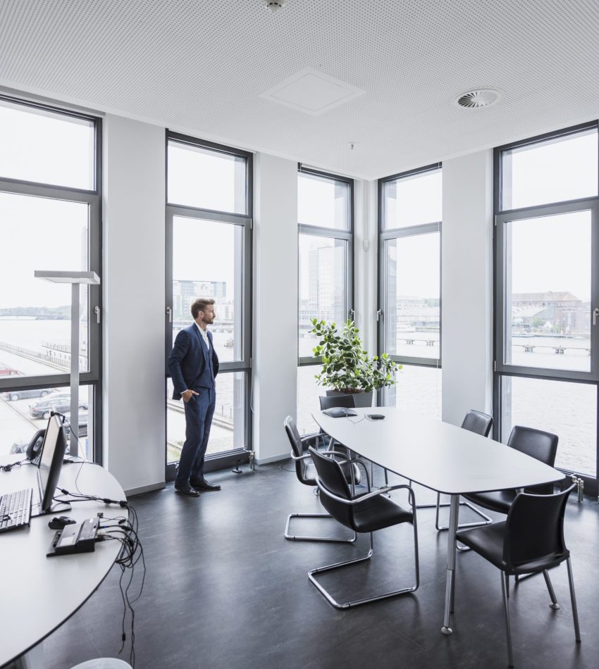 Businessman standing in his office looking out of the window